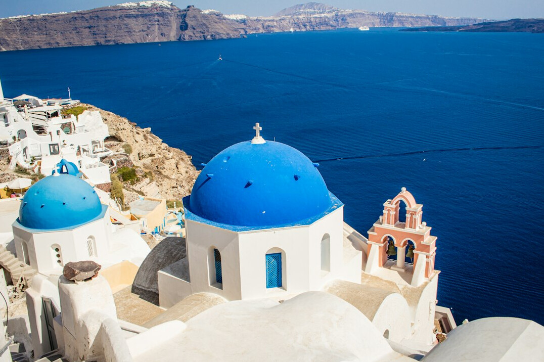 Santorini white buildings with blue domes above the sea